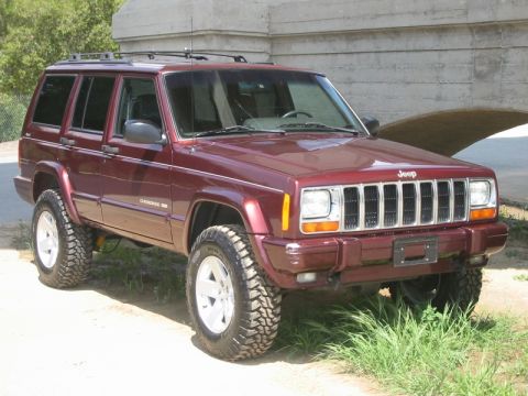 2000 Jeep Cherokee - This maroon 2000 Jeep Cherokee features a lifted suspension and aggressive off-road tires, ready for adventure.