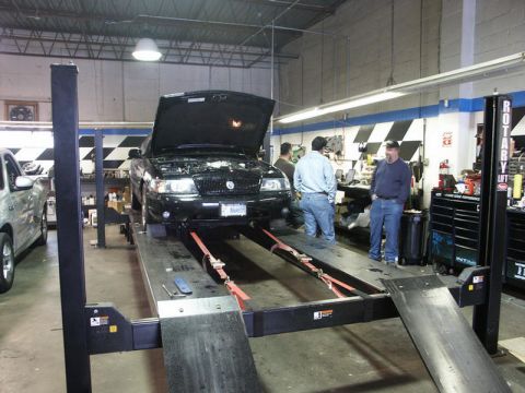 2001 Mercury Grand Marquis - Black 2001 Mercury Grand Marquis undergoing service on a hydraulic lift in a garage.
