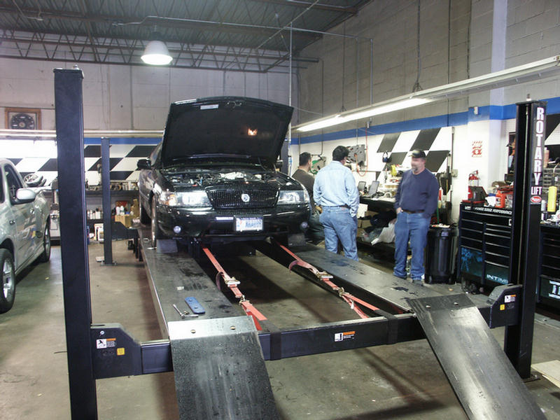 2001 Mercury Grand Marquis on a lift with hood open, another car to the left