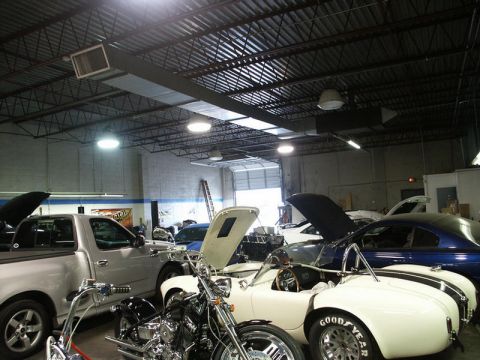 2001 Mercury Grand Marquis - A garage scene displays a white convertible with racing stripes, a silver pickup truck, and a blue coupe, along with motorcycles.