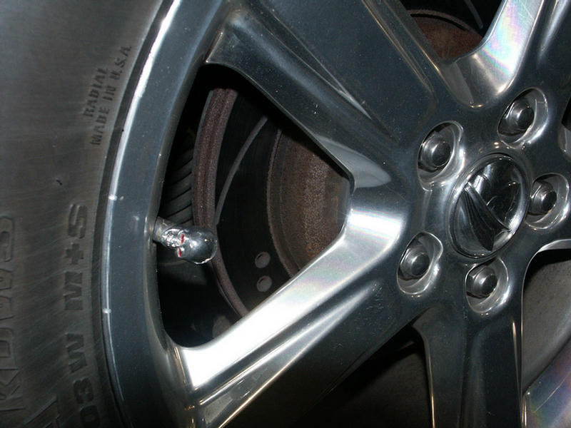 Close-up of a chrome alloy wheel with a tire and brake rotor visible
