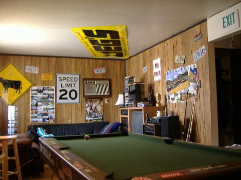 1979 Ford Bronco - A room decorated with various signs, posters, and license plates, a pool table in the foreground.