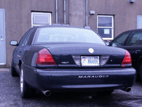 2001 Mercury Grand Marquis - Rear view of a black Marauder sedan, identified by its badging, parked next to another vehicle.