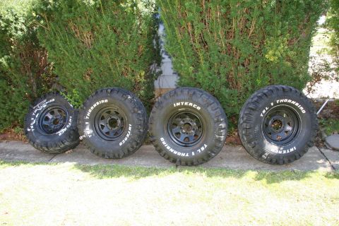 1990 Ford Bronco - Four off-road tires with white lettering, including Interco Thornbird TSL, are displayed on grass.