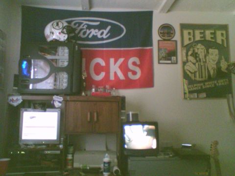 1985 Ford F-150 - A room decorated with a Ford flag, beer advertisement, and electronic equipment.