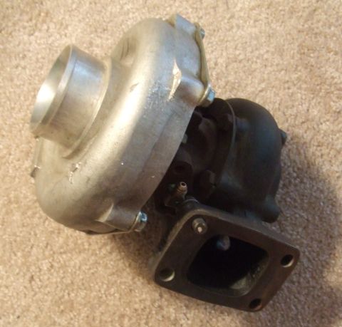 1995 Ford Probe - Turbocharger part shown on carpeted surface.