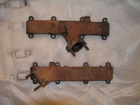 1967 Ford Galaxie - A pair of old, rusty exhaust manifolds are shown, likely for an older vehicle's engine.