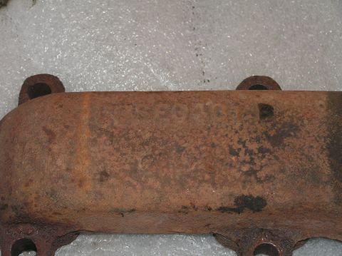1967 Ford Galaxie - Close-up of a rusty exhaust manifold showing casting numbers C6AE-9430-B, likely a Ford part.
