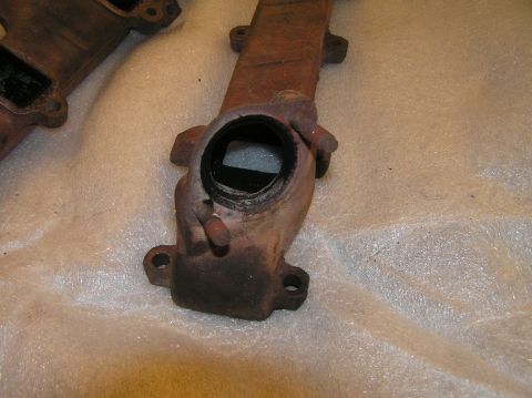 1967 Ford Galaxie - Close-up of two exhaust manifold parts, likely for an older vehicle.