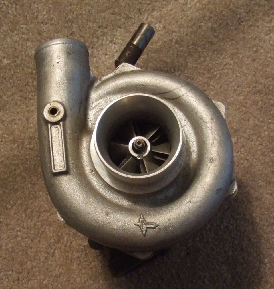 Turbocharger with visible impeller blades and a metal tag with '10' stamped on it
