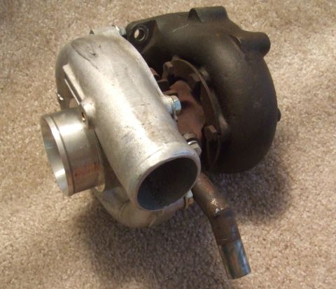1995 Ford Probe - Turbocharger part shown on a carpeted surface. The registry claims it is a 1995 Ford Probe, but this is incorrect.