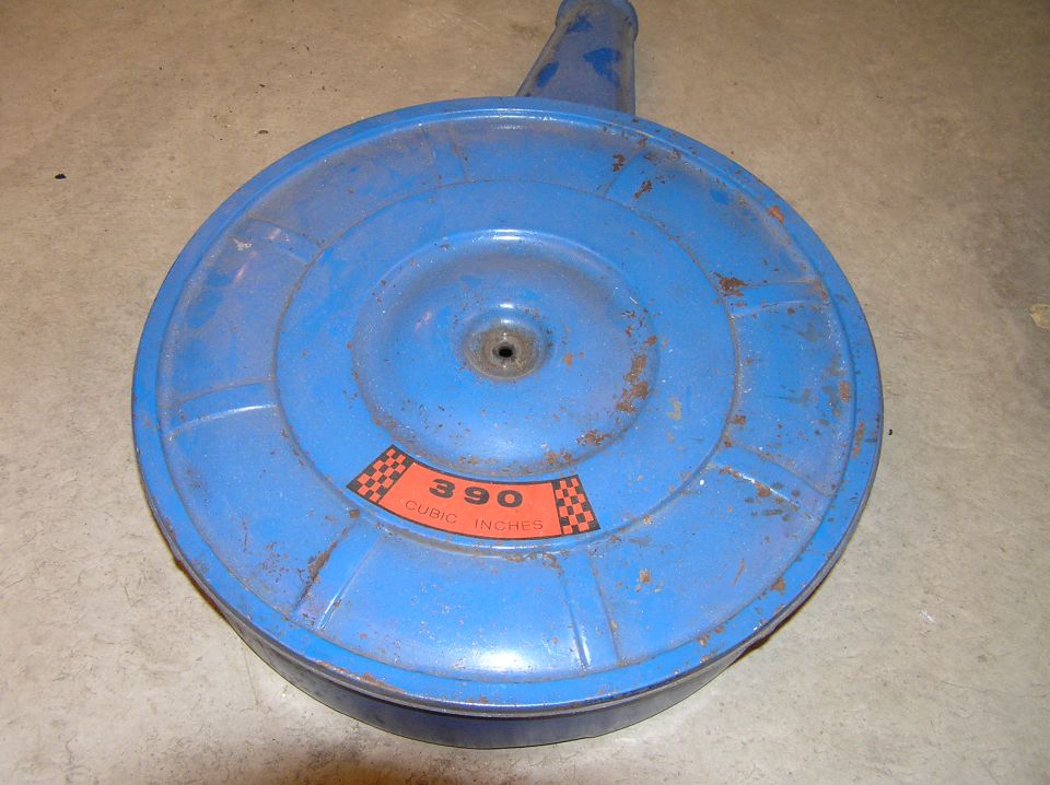 Blue Ford 390 cubic inch air cleaner lid with orange decal on concrete floor