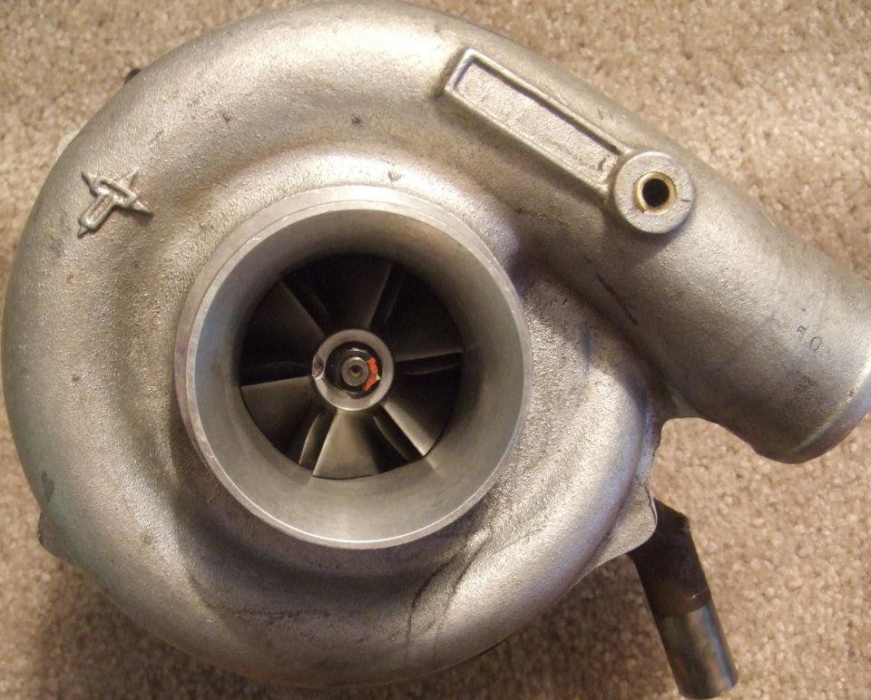 Silver turbocharger with visible impeller blades and exhaust housing