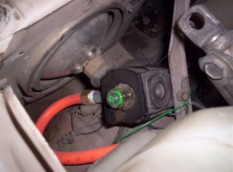 1987 Suzuki Samurai - Close-up view of an engine component with an attached orange hose and a green indicator light.