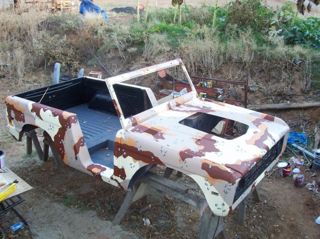 1974 Ford Bronco body with desert camouflage paint, on sawhorses outdoors