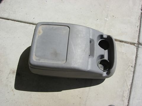 1987 Ford Bronco - This is a vehicle's center console, a flip-top storage area and dual cup holders.