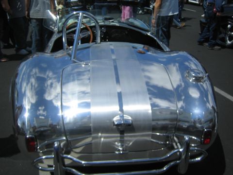 1968 Ford Mustang - A highly reflective Shelby Cobra replica is shown from the rear, dual racing stripes.