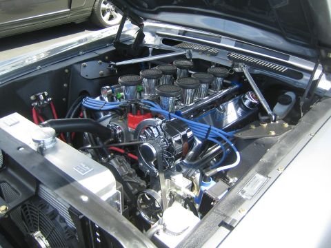 1968 Ford Mustang - Engine bay of a Ford V8 with custom modifications, including multiple carburetors and an aftermarket radiator.