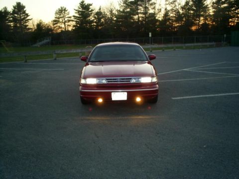 1995 Ford Crown Victoria - A red 1995 Ford Crown Victoria is shown from the front in a parking lot at dusk.