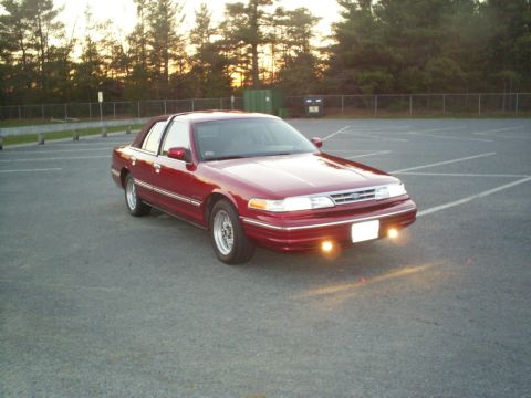 1995 Ford Crown Victoria - A red 1995 Ford Crown Victoria is seen from a three-quarter front view in a parking lot at dusk.