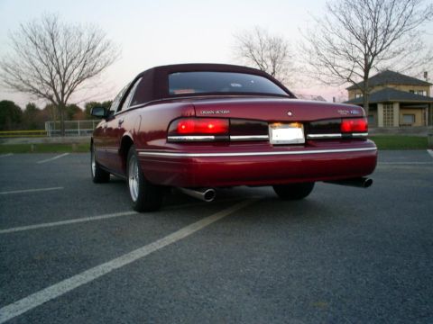 1995 Ford Crown Victoria - Rear view of a red 1995 Ford Crown Victoria convertible parked in a lot.
