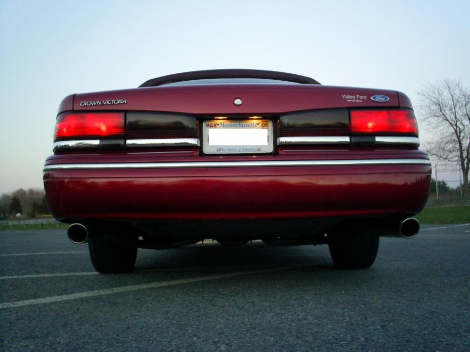 Red 1995 Ford Crown Victoria rear view with license plate frame reading 'Valley Ford'