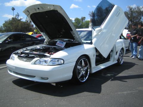 1968 Ford Mustang - Modified white Ford Mustang with custom doors and wheels at a car show.