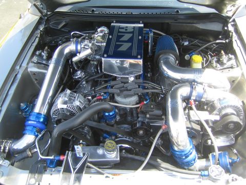1968 Ford Mustang - Customized engine bay features a chrome intake manifold, turbocharger, and vibrant blue accents.