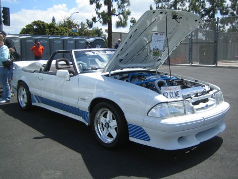 1968 Ford Mustang - This 1987 Ford Mustang convertible features custom blue racing stripes and an open hood revealing the engine.