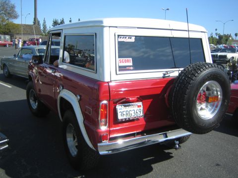 1968 Ford Mustang - A red and white Ford Bronco is parked outdoors, with other vehicles visible in the background.