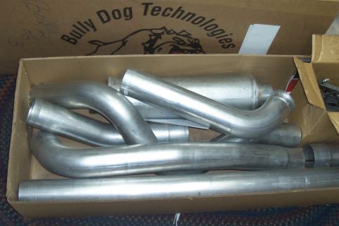 1994 Ford F-150 - A box contains various exhaust system components, including pipes and a muffler, with the Bully Dog Technologies logo visible on the box.