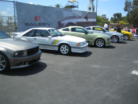 1968 Ford Mustang - Multiple Ford Mustangs parked in a row, with a Saleen banner in the background.