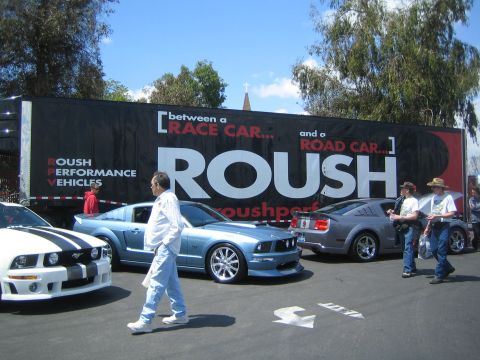 1968 Ford Mustang - Several Ford Mustangs are displayed in front of a large trailer advertising Roush Performance Vehicles.