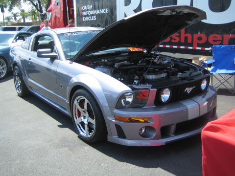 1968 Ford Mustang - This silver Mustang features racing stripes and its hood is open, revealing the engine bay.