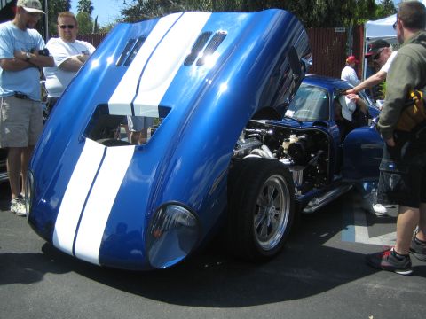 1968 Ford Mustang - A blue Shelby Cobra replica is displayed with its hood and door open, revealing the engine and interior.