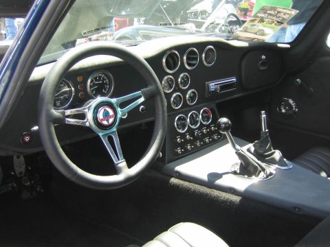 1968 Ford Mustang - The interior of a Shelby Cobra shows a classic dashboard with multiple gauges and a prominent shifter.