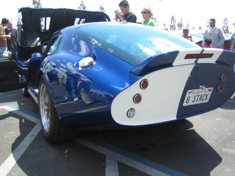 1968 Ford Mustang - A blue and white Shelby Cobra Daytona Coupe is seen from the rear at a car show. The custom license plate reads '8 STACK'.