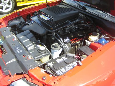 1968 Ford Mustang - Close-up of a red engine bay, showing the air intake and valve covers.