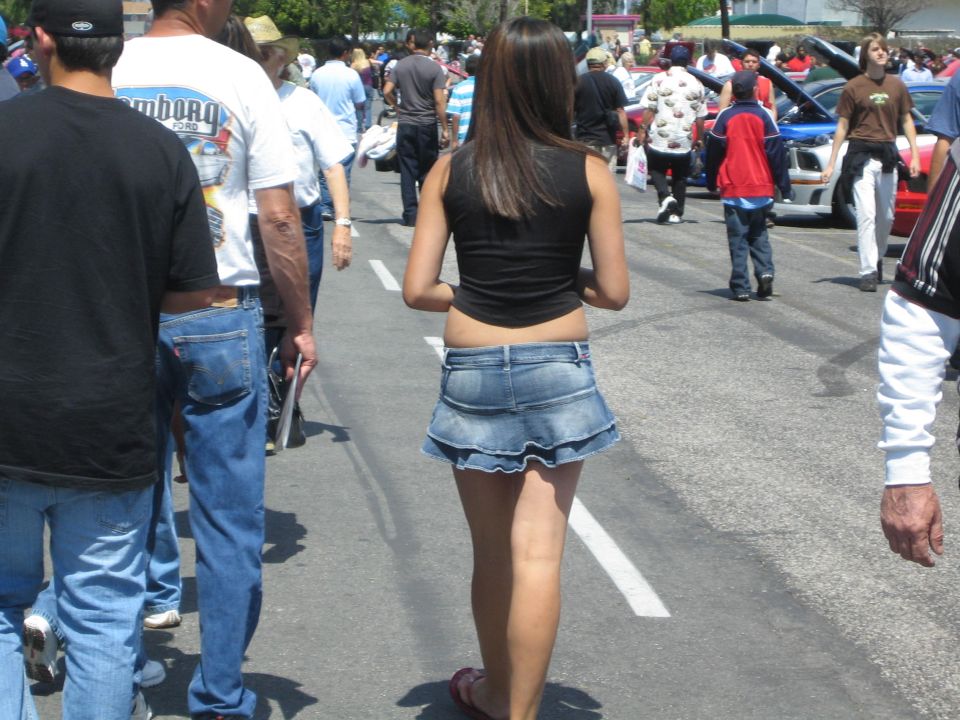 People walking past cars at an outdoor event