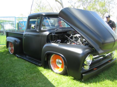 1968 Ford Mustang - A matte black 1956 Ford F-100 pickup truck is displayed with its hood open, revealing the engine bay.