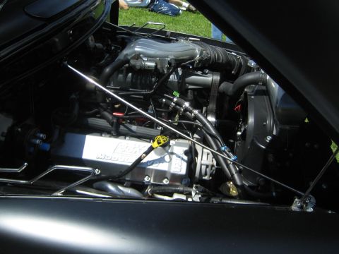 1968 Ford Mustang - Engine bay view showing chrome valve covers and intake manifold, with some hoses and wiring visible.