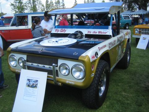 1968 Ford Mustang - A customized Ford Bronco, possibly a race truck, is displayed on a grassy field with other vehicles around.