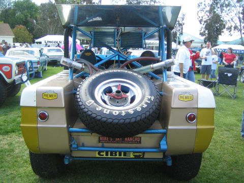 1968 Ford Mustang - A custom buggy with a spare tire and dual exhaust pipes is displayed at an outdoor event.