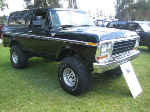 1968 Ford Mustang - A black Ford Bronco is parked on a grassy field, with another vehicle visible in the background.