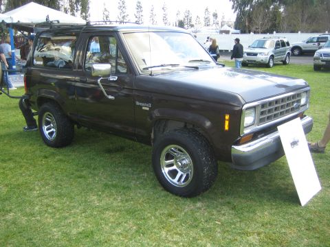 1968 Ford Mustang - A Ford Bronco II is displayed at an outdoor event, with other cars visible.
