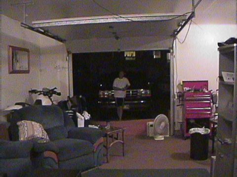 1994 Ford Bronco - A person stands in a garage doorway, illuminated by headlights of a Ford F-Series truck.