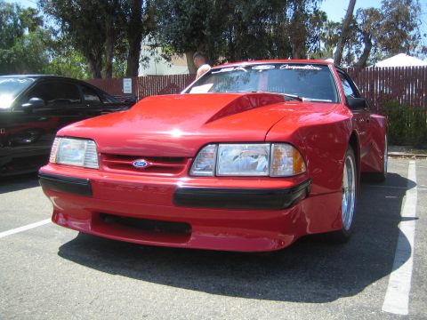 1968 Ford Mustang - This red Ford Mustang, likely from the early 1990s, has a prominent hood scoop and appears to be modified.