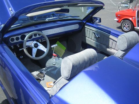 1968 Ford Mustang - The interior of a blue convertible is shown, with a red golf cart visible in the background.