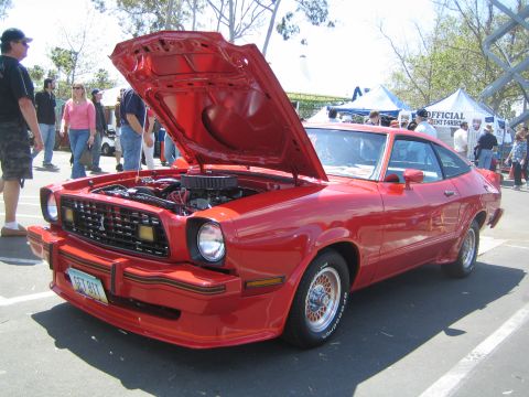1968 Ford Mustang - This red 1977 Ford Mustang II coupe is displayed with its hood open at an outdoor car show.