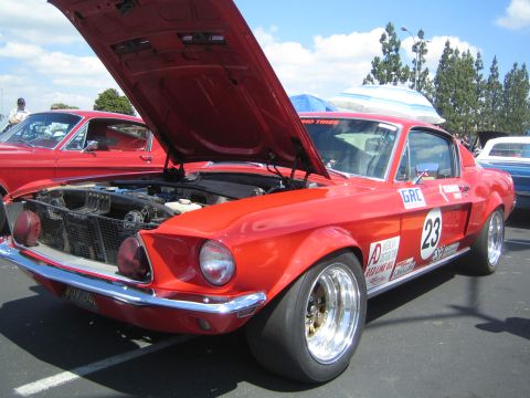 1968 Ford Mustang - A red 1968 Ford Mustang with racing decals and number 23 is displayed with its hood open.